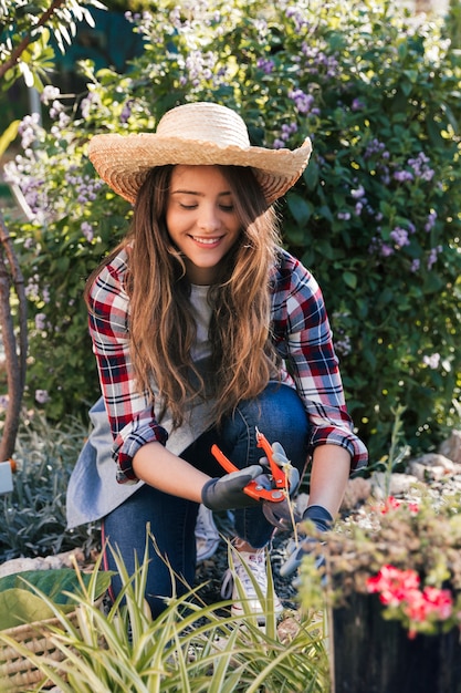 Smiling portrait of a female gardener pruning the plants