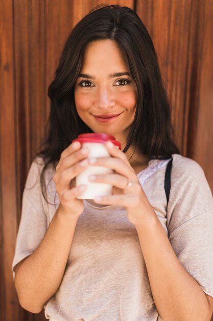 Smiling portrait of a girl holding take away coffee cup