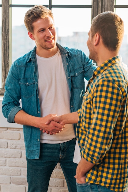 Smiling portrait of a young man shaking hands