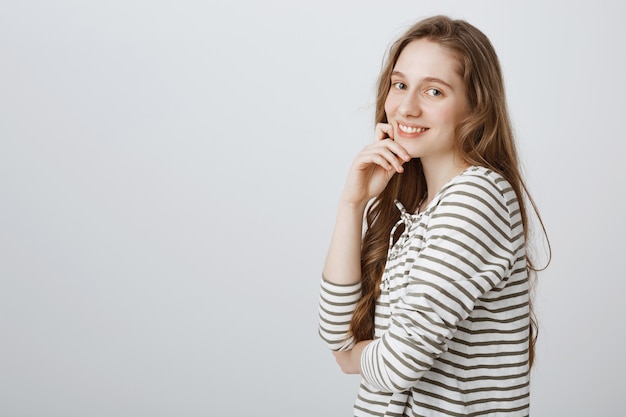 Smiling pretty girl looking happy over white wall