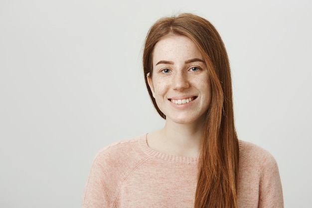 Smiling pretty redhead girl with freckles smiling