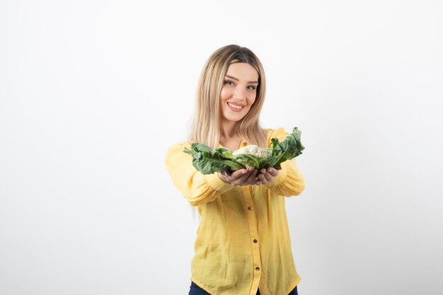 smiling pretty woman model standing and holding cauliflower.