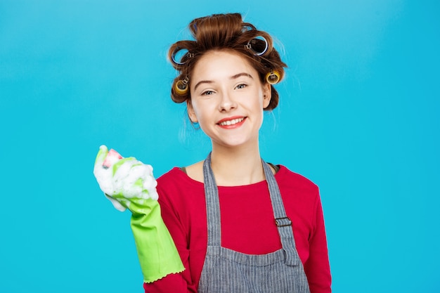 Smiling pretty woman in pink outfit with green gloves