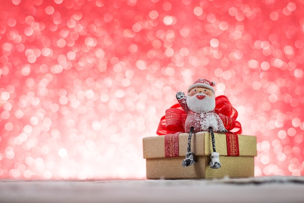 Free photo smiling santa claus sitting on a christmas gift