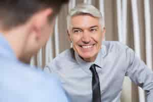 Free photo smiling senior businessman talking to partner