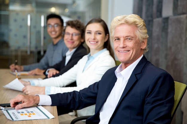 Free photo smiling senior leader at meeting with his team