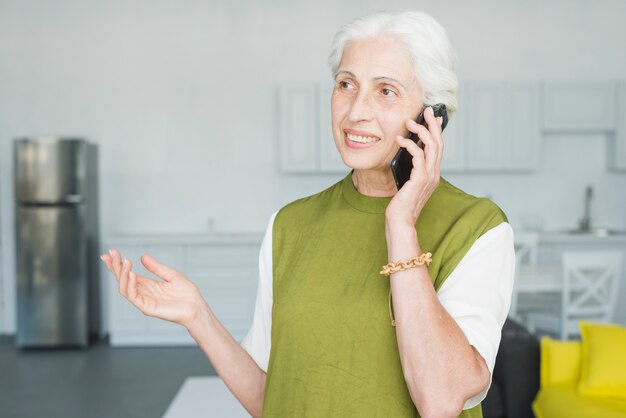 Smiling senior woman talking on mobile gesturing