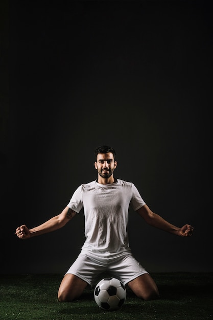 Free photo smiling sportsman sitting near ball