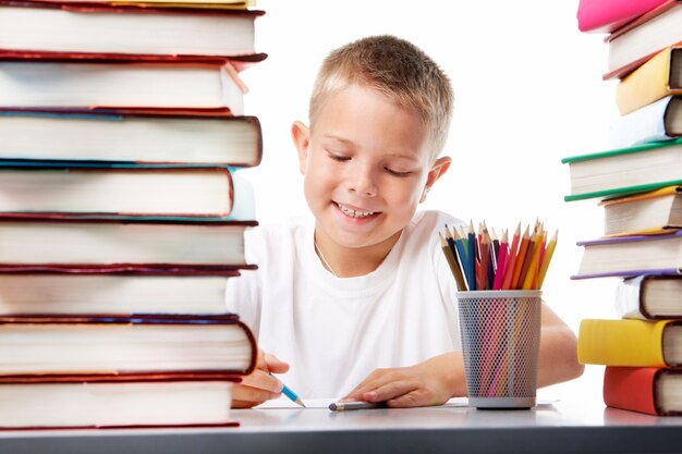 Smiling student drawing with a blue crayon