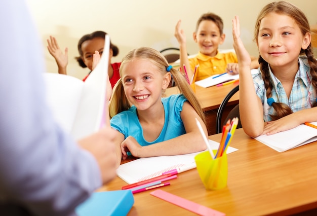 Free photo smiling students paying attention in class