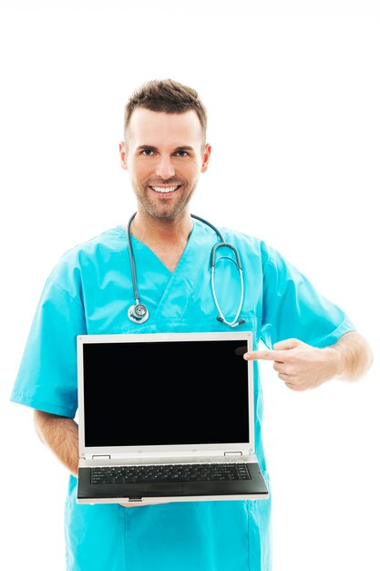 Smiling surgeon pointing at laptop