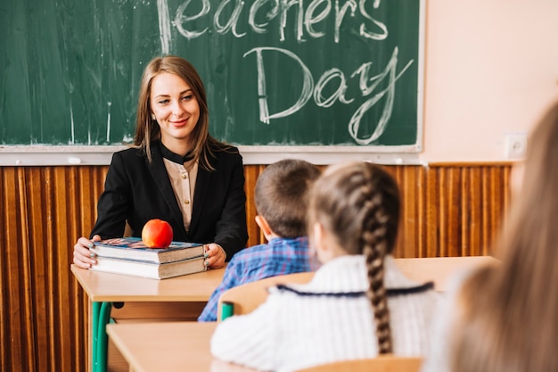 Smiling teacher sitting at table