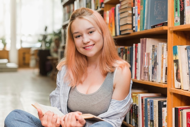 Smiling teenager with book looking at camera