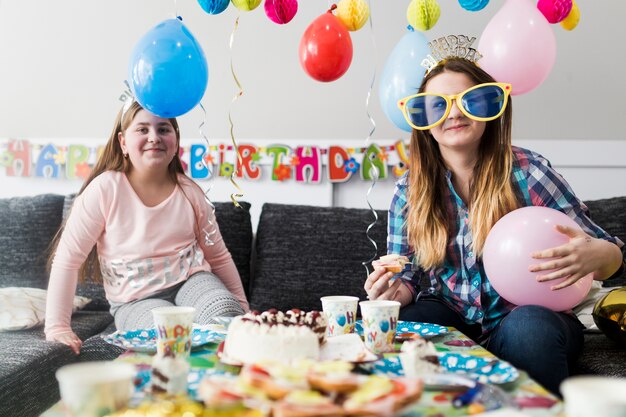 Smiling teenages eating on birthday party