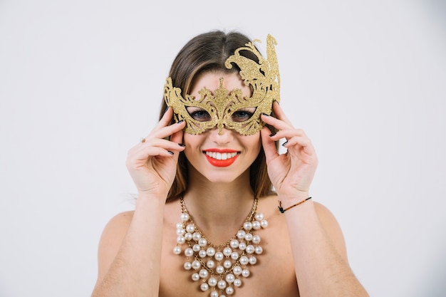 Free Photo smiling topless woman wearing golden decorative carnival mask and necklace