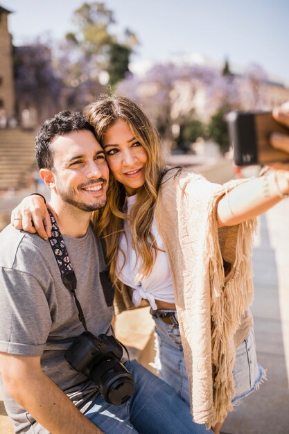 Smiling tourist taking self portrait on cell phone