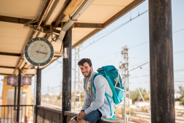 Smiling traveler waiting for the train