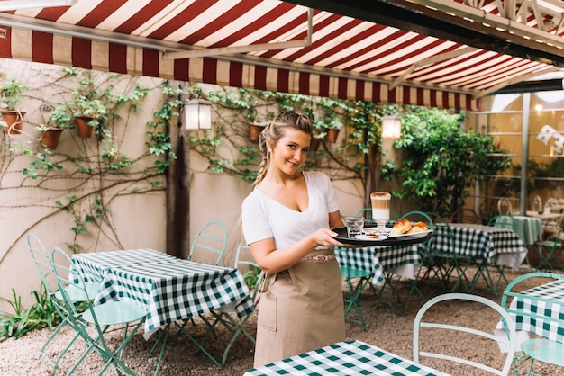 Smiling waitress holding tray