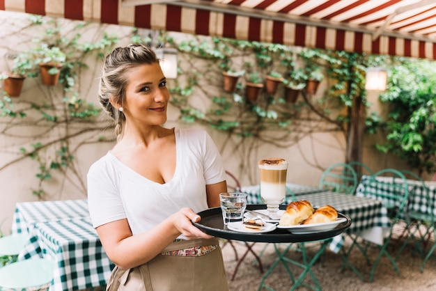 Free Photo smiling waitress holding tray