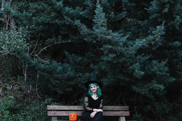 Free Photo smiling witch sitting on bench