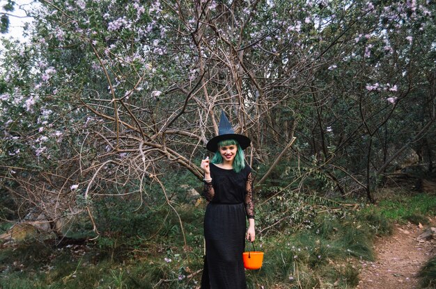 Smiling witch in spooky forest