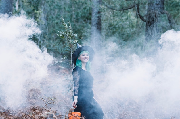 Free Photo smiling witch standing in smoke