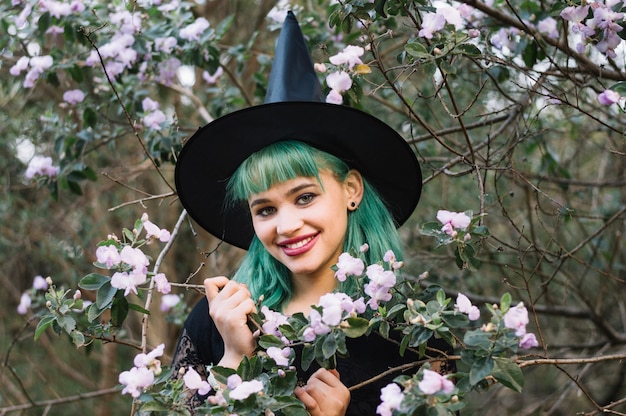 Free photo smiling witch woman with blooming branch