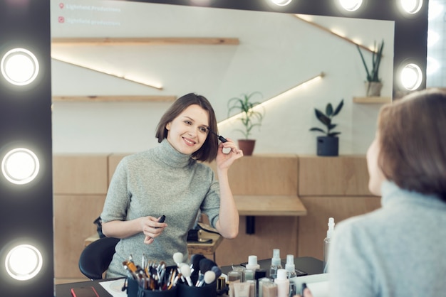 Smiling woman applying mascara