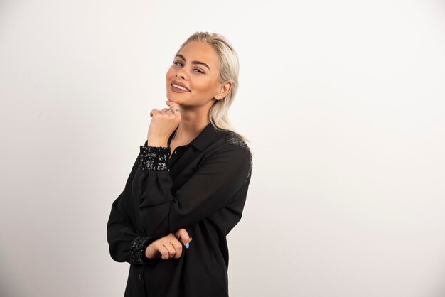 Smiling woman in black shirt posing on white background. High quality photo