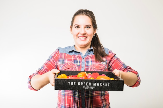 Smiling woman carrying tomatoes and peppers