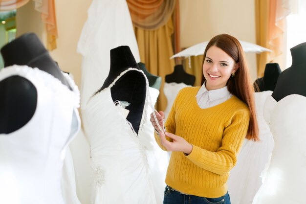 Free photo smiling woman chooses bridal gown