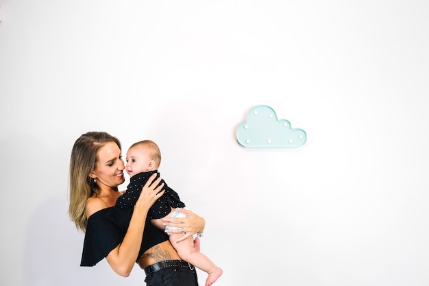 Smiling woman cuddling cute baby