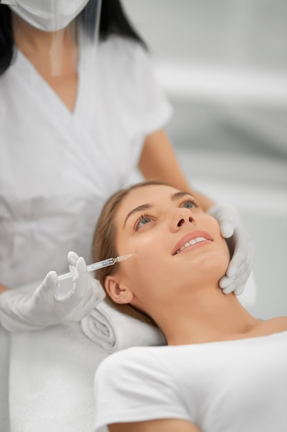 Free photo smiling woman doing procedure for tighten skin