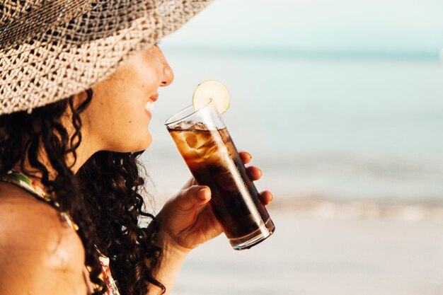 Smiling woman drinking cooling beverage