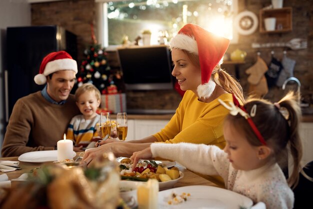 Smiling woman eating Christmas lunch with her family in dining room