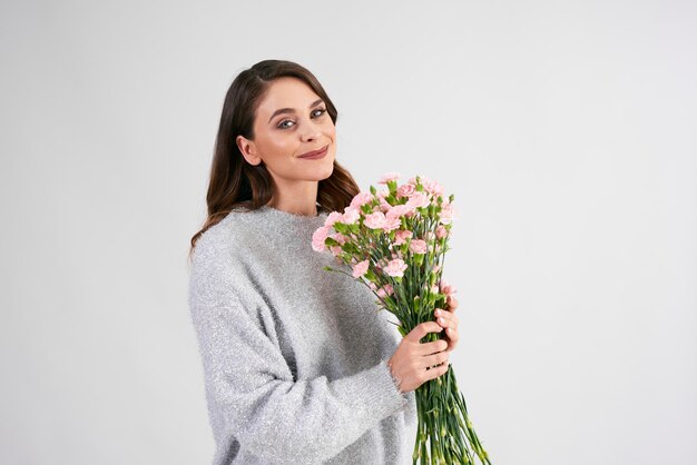 Smiling woman holding bunch of flowers