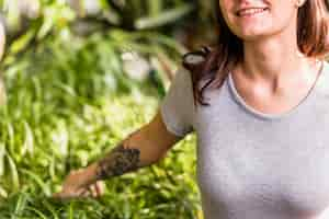 Free photo smiling woman holding green leaves of plants