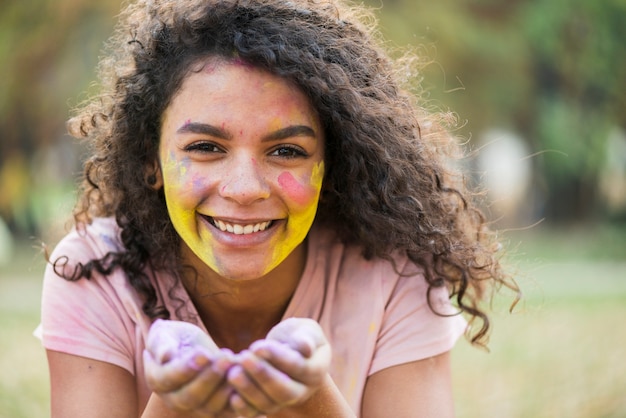 Free photo smiling woman holding powdered paint in her hands