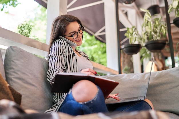 Smiling woman learning at home with laptop.