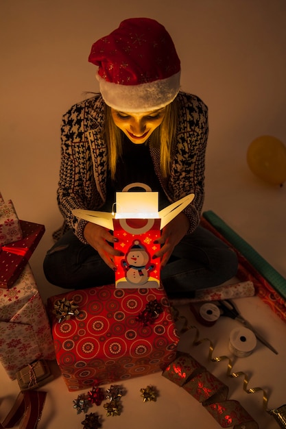 Smiling woman looking into gift box