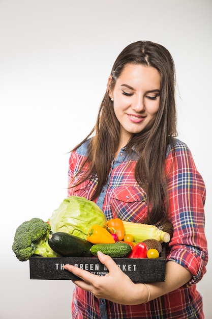 Free photo smiling woman looking at vegetables