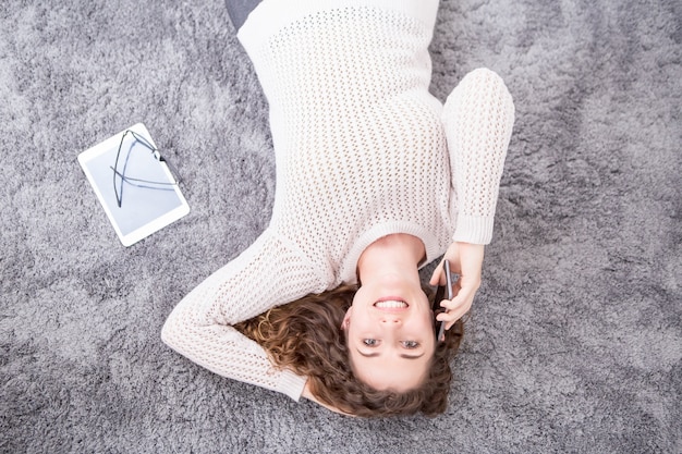 Free Photo smiling woman lying on floor and calling on phone