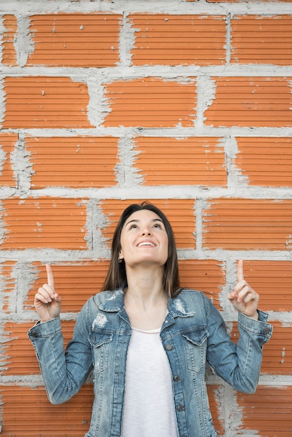 Free Photo smiling woman pointing up 