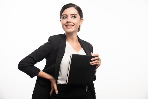 Smiling woman posing with notebook on white background. High quality photo