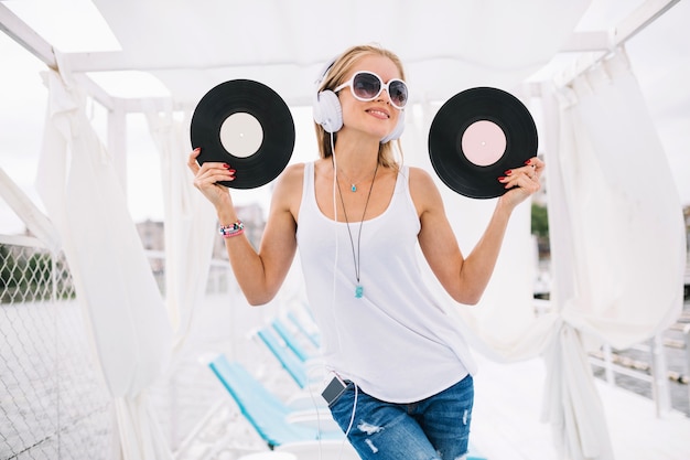 Free Photo smiling woman posing with vinyls