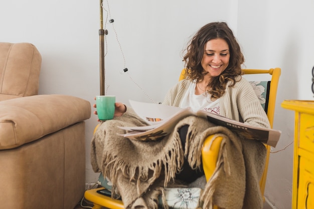 Free photo smiling woman reading newspaper