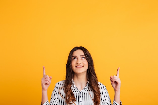 Smiling woman in shirt pointing and looking up