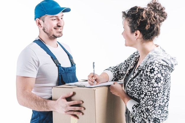 Smiling woman signing for parcel near courier