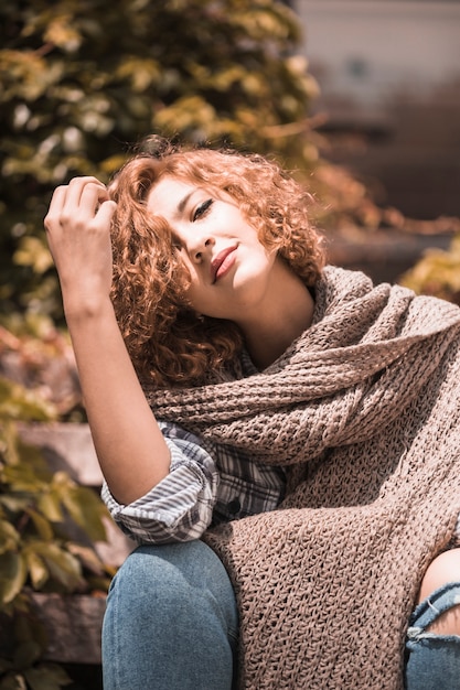 Free photo smiling woman sitting on steps with bending head