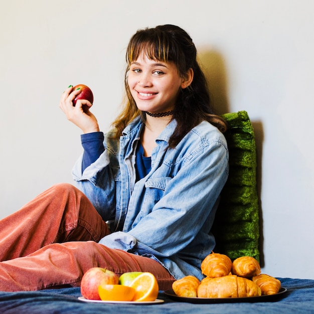 Smiling woman sitting with apple